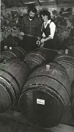 Dick and Nancy Ponzi stand in a room of wine barrels.