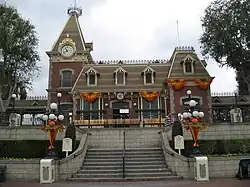 A flight of stairs lead to an old-fashioned railroad station building.