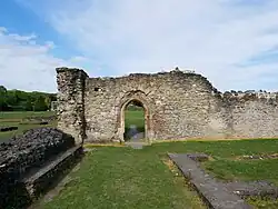 Remains of a stone wall with a doorway that would have provided access to the cloister around the courtyard