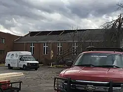 A brick single-story office building with part of its roof missing