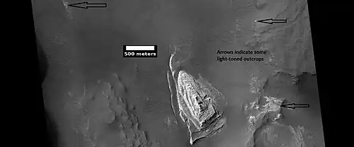 Light toned butte on floor of crater, light toned butte, as seen by HiRISE. Arrows show outcrops of light toned material (probably sulfate-rich and once covering the whole floor).