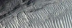 Close view of layers, as seen by HiRISE under HiWish program. A ridge cuts across the layers at a right angle.