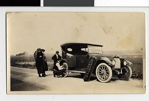 Edward J. Naylor repairing a tire on a 1913 Overland Touring Car, Blue Earth County, Minnesota