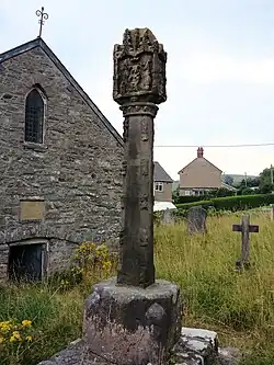 Derwen Cross, with the church behind