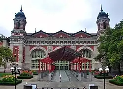 Entrance to the Main Building, seen from the south. The entrance canopy can be seen in the foreground, and the three arches of the south facade, as well as two of the ornamental towers, can be seen in the background.