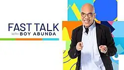 An image of Boy Abunda smiling and pointing his fingers. The show title is displayed on the left side of the image, over a white background.