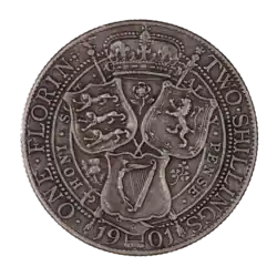 The reverse of a 1901 British Florin, featuring the heraldic shields of England, Scotland, and Ireland arranged in a triangular formation around a thistle, shamrock, and rose. A royal crown is placed above, bordered by two sceptres crossed at the centre of the shields and coin. The date at bottom, 1901, is interrupted by the bottom of the Irish shield. Arcing around the coin at left is ONE FLORIN, while at right is TWO SHILLINGS.
