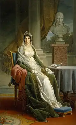 Letizia Bonaparte seated in formal attire with a red imperial mantle, next to a bust of Napoleon