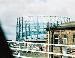 The gas holders of Provan Gas Works, on the skyline in Glasgow; pipework and the booster house can also be seen.