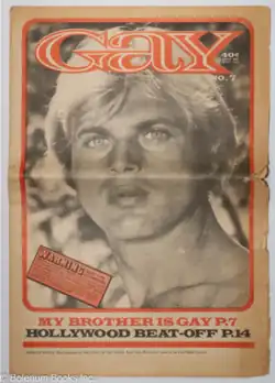 A black and white photo of a young man with blonde hair and striking eyes fills the cover of "Gay" newspaper, issue No. 7. The headline text overlays the bottom of the photo and announces articles titled "MY BROTHER IS GAY" and "HOLLYWOOD BEAT-OFF". A smaller "WARNING" box in the lower left corner alerts readers about adult content.
