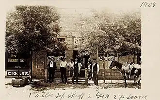 George Hennessey (center), manager of the Bucket of Blood Saloon, outside the saloon in 1908
