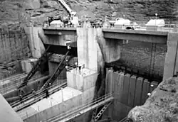 View of two large gates separated by concrete piers, holding back floodwater.