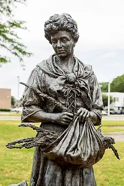Statue of a woman holding a bag with herb