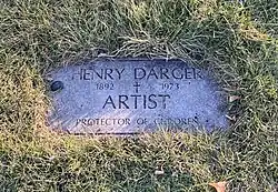 A photo of a grave marker reading "Henry Darger, 1892-1973, Artist, Protector of Children"