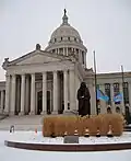 Enoch Kelly Haney's Guardian is on top of the dome, while Allan Houser's Guardian is in front of the Capitol