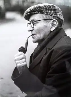 An old man smoking a pipe, looking to the left