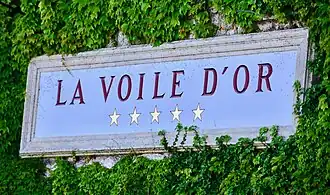 Image of a sign with the hotel's name and five stars on it.