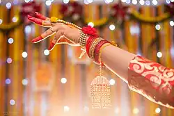A Bengali Muslim bride's hand adorned with alta on her Gaye Holud