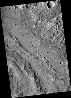 Northeastern Henry crater showning layers at lower left and linear hills called yardangs, sculpted by wind