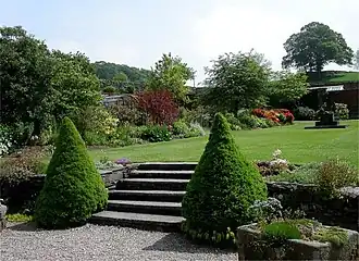 An expanse of lawn surrounded by flowers within the walled garden.