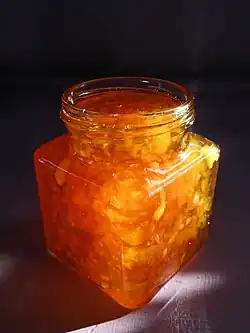 A jar filled with orange marmalade.