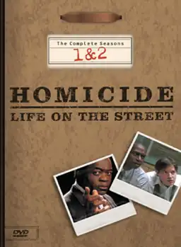 A DVD box-set cover with a background resembling a brown file folder, including a metal clip at the top. The words "Homicide: Life on the Street" are printed in the middle of the cover, with the words "The Complete Seasons 1&nbsp;&&nbsp;2" above it. Underneath the words are two images resembling photographs, one with a man wearing a suit jacket looking straight forward and pointing with his index finger, and the other of two men wearing dress shirts leaning forward and looking sideways.