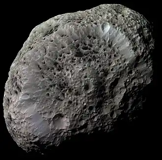 Image 15 Hyperion Photo credit: Cassini orbiter Hyperion, a moon of Saturn, is one of the largest highly irregular (non-spherical) bodies in the Solar System. Enhanced image processing was used to bring out details and color differences in this photo taken by the Cassini orbiter. Hyperion is entirely saturated with deep, sharp-edged craters that give it the appearance of a giant sponge. Dark material fills the bottom of each crater. More selected pictures