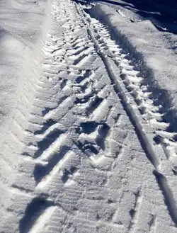 Compaction in about 5 centimetres (2&nbsp;in) of snow left behind a snow tire, showing tread-snow interaction.