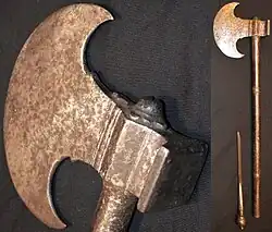 Sindhi tabar battle axe, late 18th century or earlier, crescent shape 12&nbsp;cm (5&nbsp;in) long head with a square hammer opposite of the blade, 55&nbsp;cm (22&nbsp;in) long steel haft, the end of the haft unscrews to reveal a 12&nbsp;cm (5&nbsp;in) slim blade. Heavily patinated head and handle with traces of engraving.