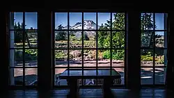 photo shows a table in front of a large set of windows and outside the windows, Mt. Hood is visible