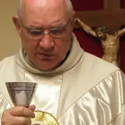 A photo of Carlos Buela holding a chalice while celebrating Mass