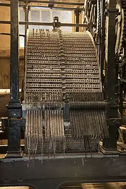 Large metal cylinder with pegs connected to gears