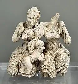 Two women and a child; 1400-1300 BC; ivory; height: 7.8&nbsp;cm; National Archaeological Museum (Athens)[14]