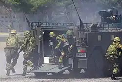 CRR soldiers rushing from a Type 96 APC