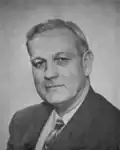 A photographic portrait of a man wearing a suit