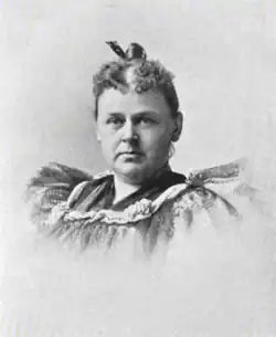A white woman wearing a ruffled dress, hair in an updo
