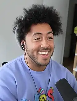 Johnson smiling and wearing a blue shirt and gray knit cap