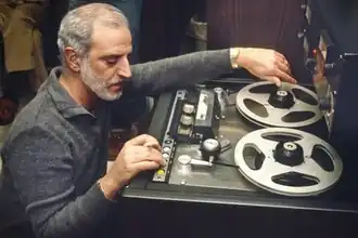 A middle-aged man operating a tape machine