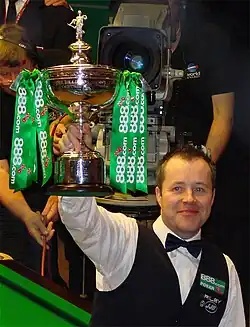 John Higgins lifting a trophy