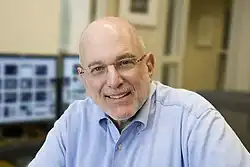 man with beard and computers in background