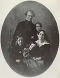 A black-and-white photograph of a mother and father posed with their son and two daughters