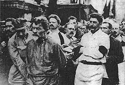 Mikhail Kalinin and Joseph Stalin carry a coffin. Leon Trotsky stands behind Kalinin.
