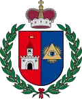 A coat of arms depicting a grey castle on a red background on the left and a blue eye in a yellow triangle on the right