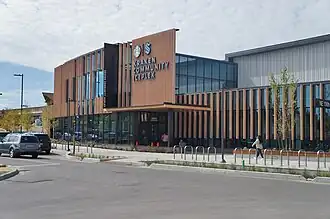 View of a wood- and glass-exterior building, featuring the Starbucks logo next to the Seattle Kraken logo with the words "Kraken Community Iceplex" written below