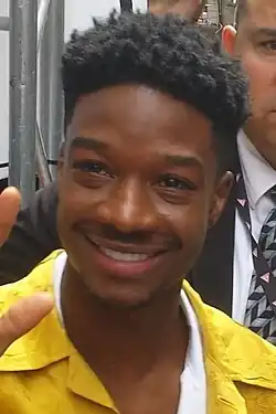 A 24-year-old man with black hair smiles towards the camera.