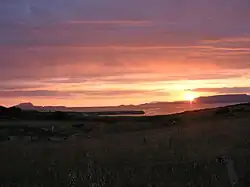 Sun set on Achill Island over Clew Bay with Lecanvey Pier in the midground and Clare Island on the horizon