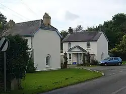 white-painted and slate-roofed lodge houses either side of a gateway