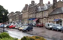 Looking west along Front Street (B6341), in the foreground, and High Street, in the background, running parallel to Front Street.