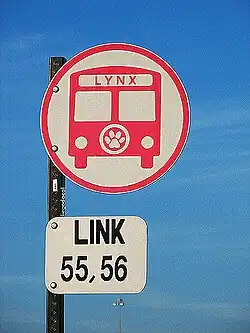 A LYNX stop sign consists of a circular sign with a "bus" icon and a rectangular sign listing connecting Links.