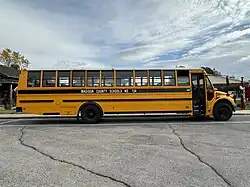 A photograph of a yellow and black school bus parked.